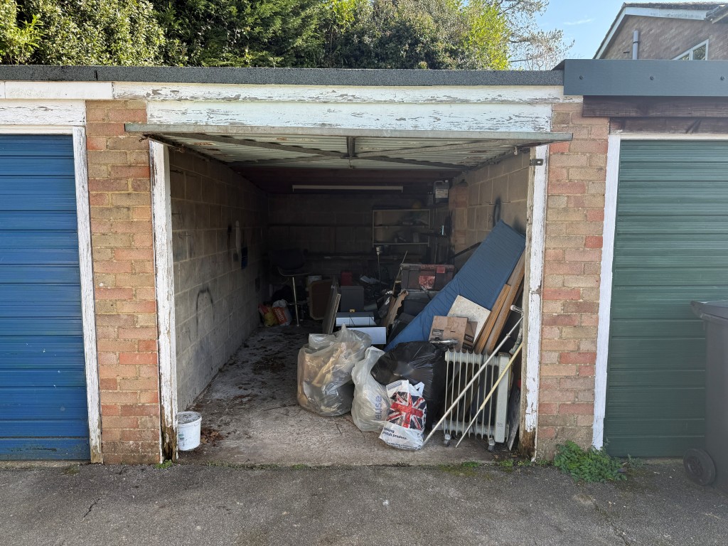 Lot: 134 - TWO-BEDROOM FLAT WITH GARAGE IN NEED OF UPDATING - View of garage with open door